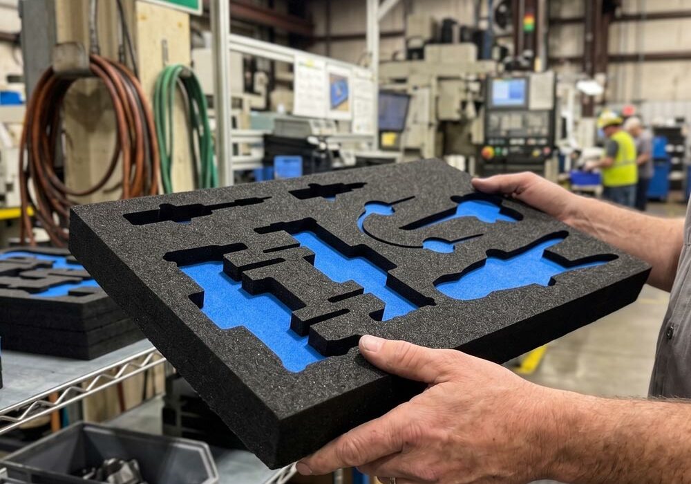 A person carrying an XLPE foam tray in a factory