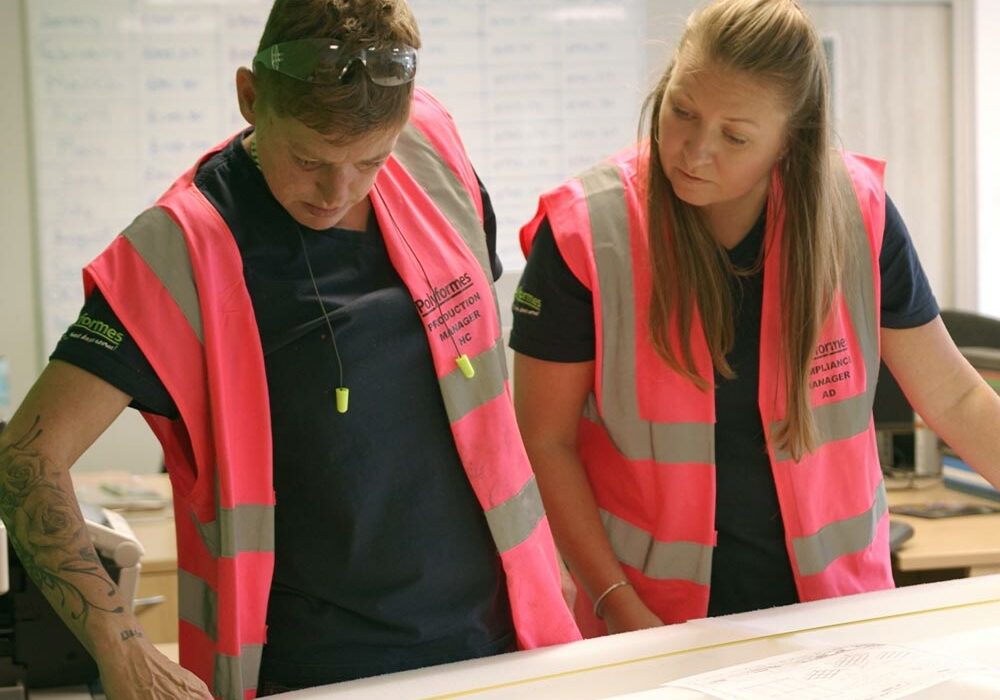Two Polyformes employees looking at a large foam insert