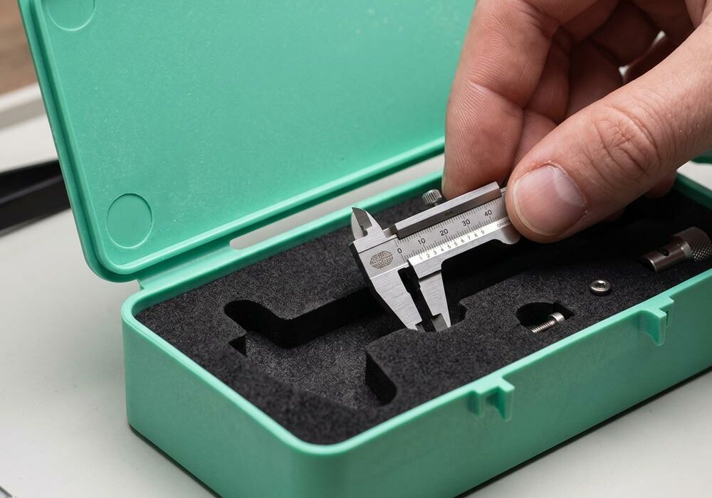 A person taking a tool out of a Unibox with foam